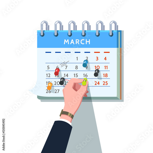 Businessman sticking push pin into month schedule