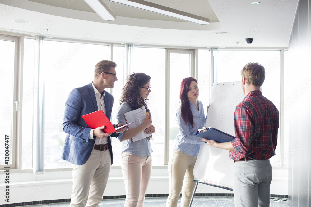 Fototapeta premium Businesswoman giving presentation to colleagues in creative office