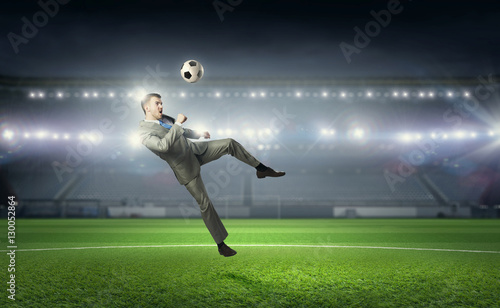 Businessman playing soccer . Mixed media