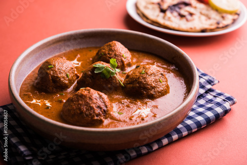 malai kofta curry - classic North Indian dish. vegetarian alternative to meatballs served with tandoori roti or indian bread and green salad, selective focus photo