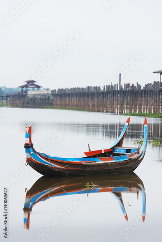 Colourful boat and U Bein Bridge on Taungthaman Lake, Amarapura, Mandalay photo