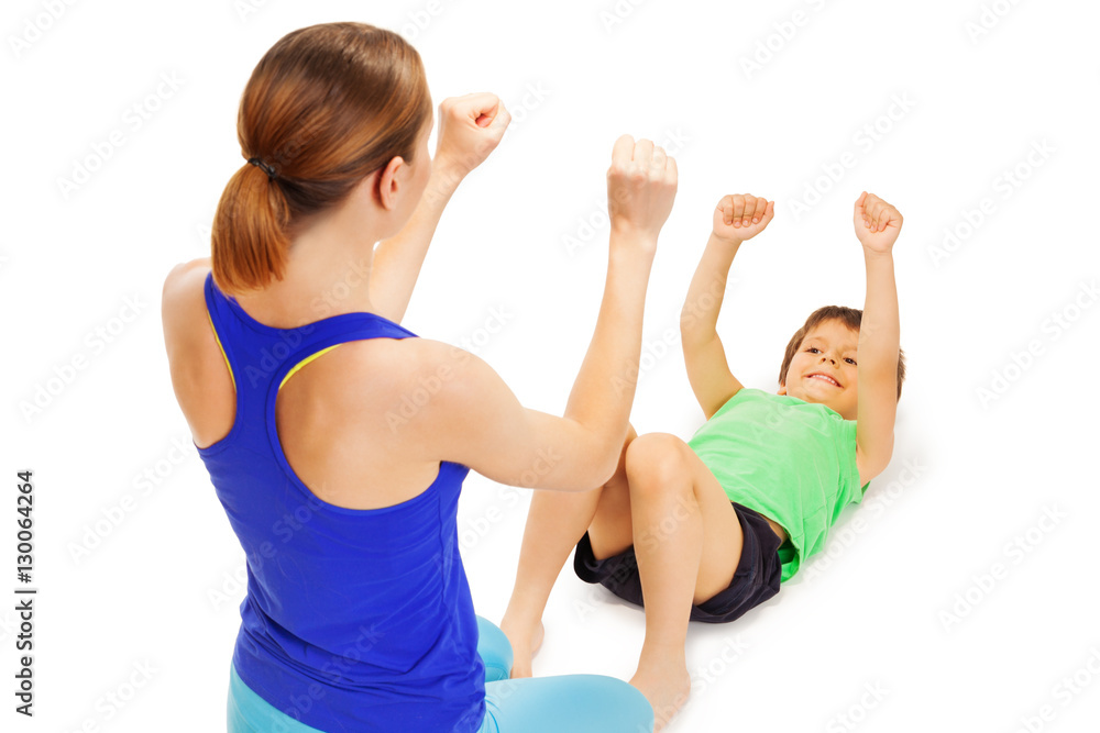 Smiling boy doing exercises with female trainer Smiling boy doing exercises with female trainer