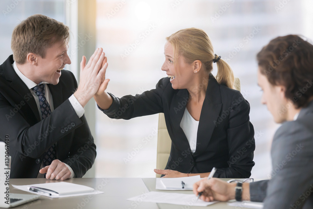 Businessman and businesswoman giving a high five Businessman and businesswoman giving a high five