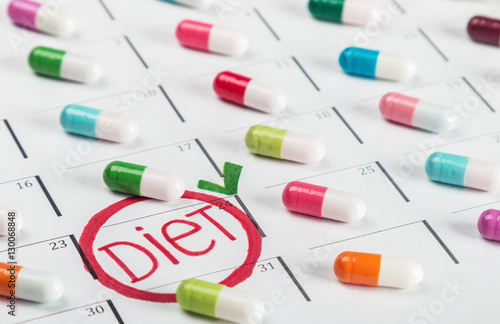 pills of different colors lie on the diet plan. Schedule of pills. Focus on the word diet