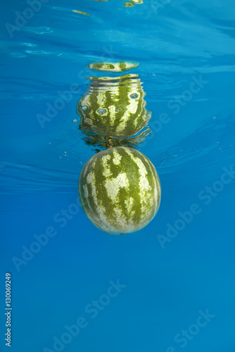 water-melon splashing in water on blue background