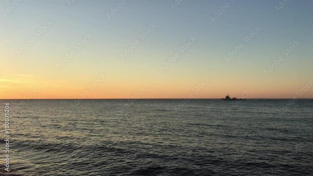 The perfect sunset view from the beach with a boat on the background, 4K The perfect sunset view from the beach with a boat on the background, 4K