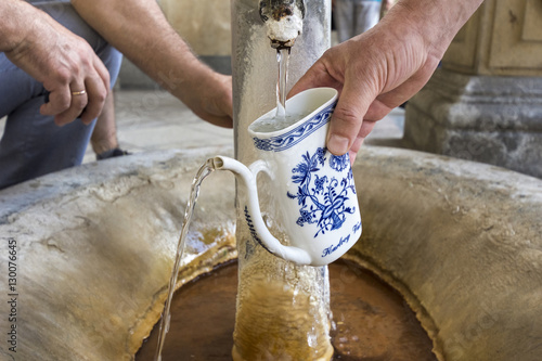 Fototapeta Filling cup with mineral water from Karlovy Vary thermal springs