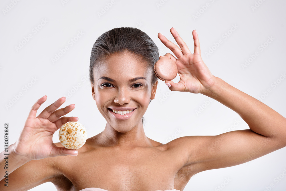 Joyfull young lady is holding round sweets Joyfull young lady is holding round sweets