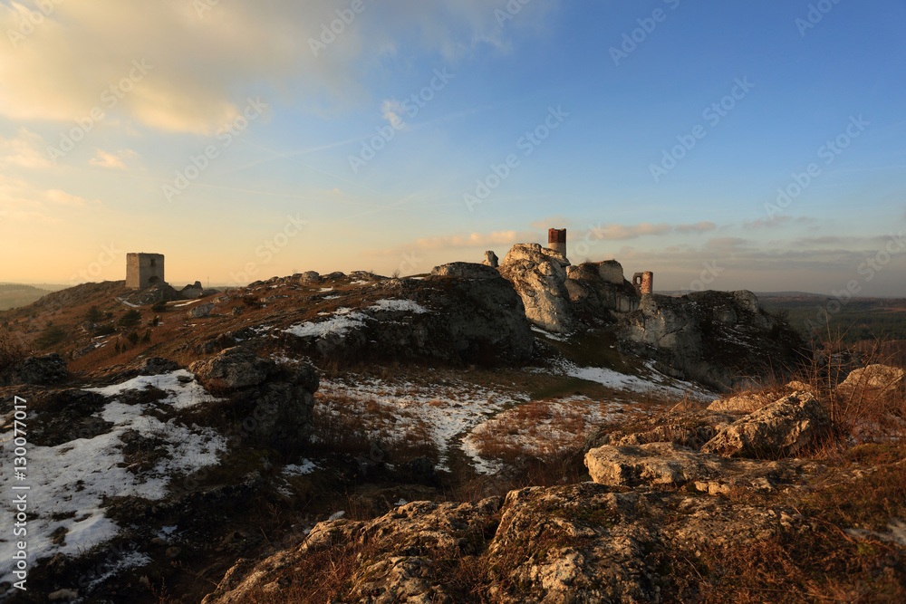 Ruiny zamku w Olsztynie zimą przed zachodem słońca.