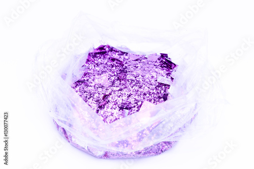 Abstract purple carborundum in plastic bag on white background. photo