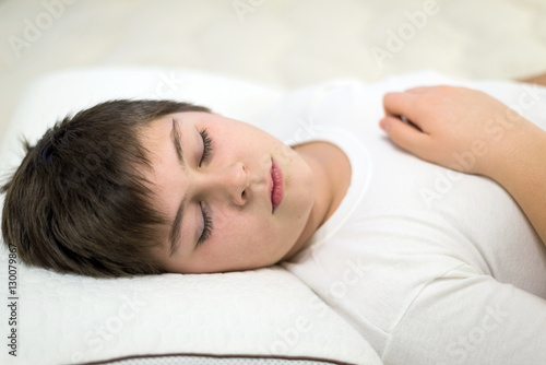 Billede på lærred Boy teenager sleeping on anatomic pillow