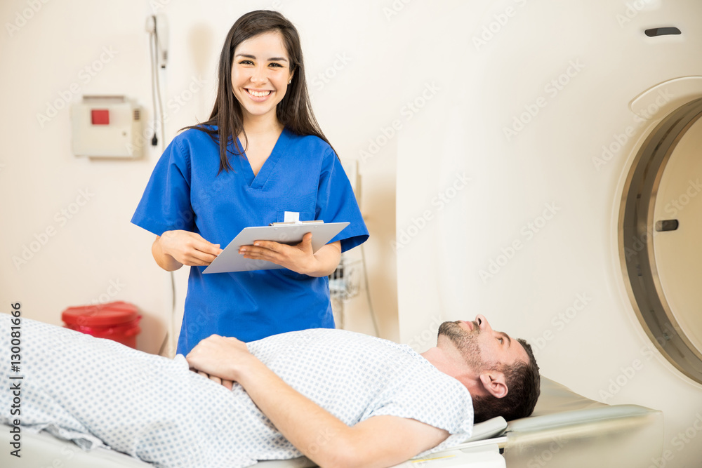 Obraz premium Beautiful nurse next to a CT scanner