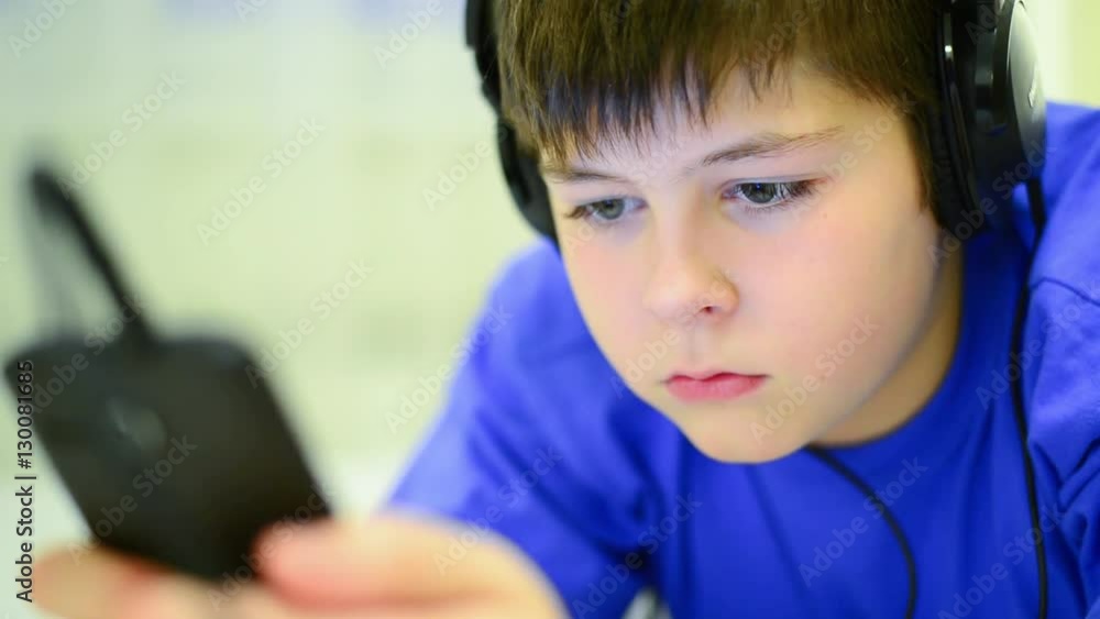 Teen using cell phone with headphones Teen using cell phone with headphones