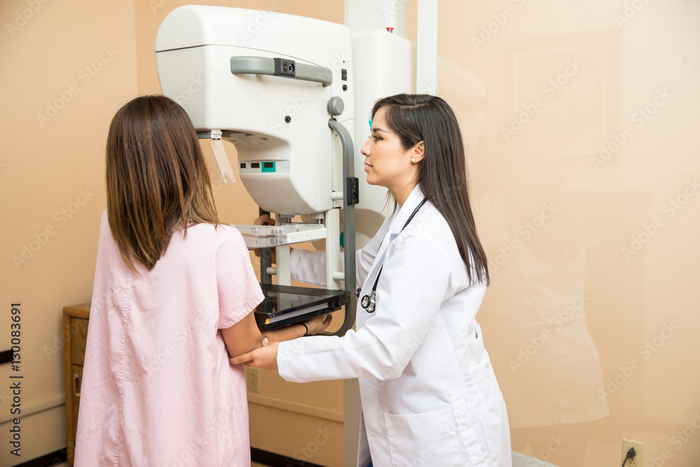Fototapeta premium Doctor helping patient get a mammogram in a hospital