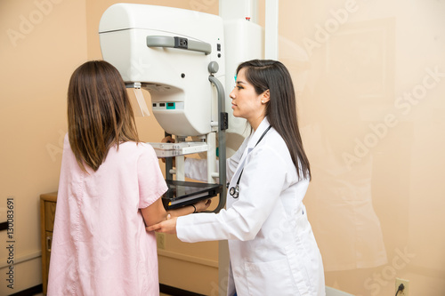 Doctor helping patient get a mammogram photo