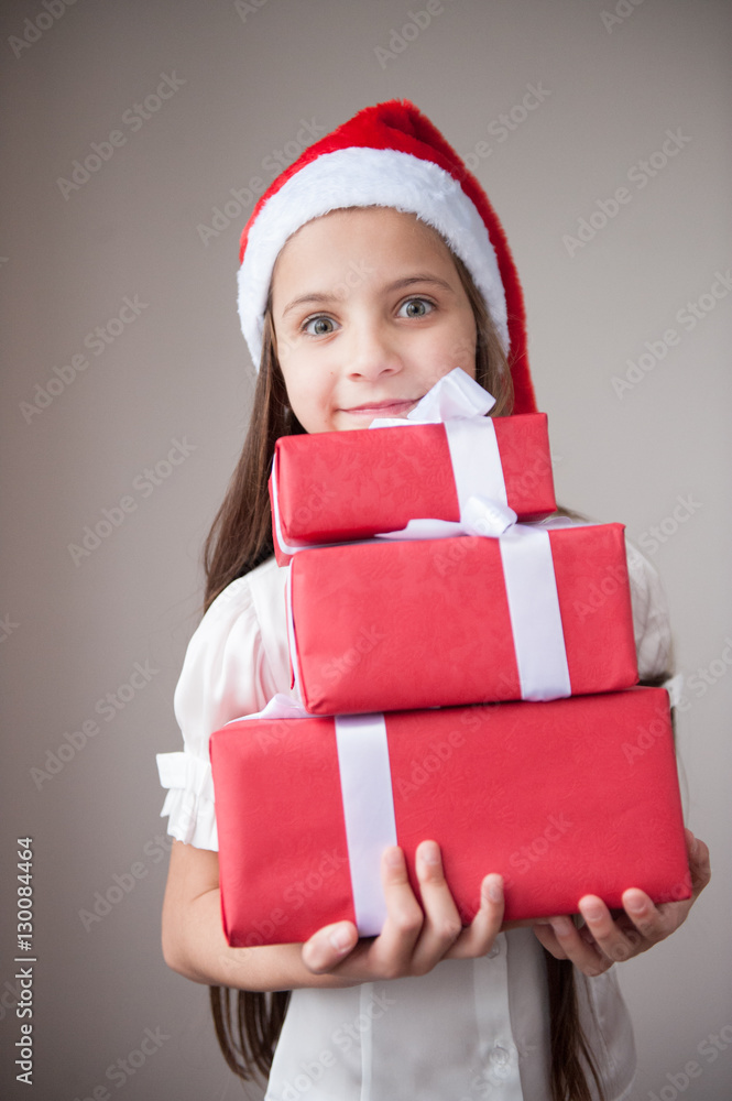 beautiful little girl in santa hat holding gifts smiling beautiful little girl in santa hat holding gifts smiling