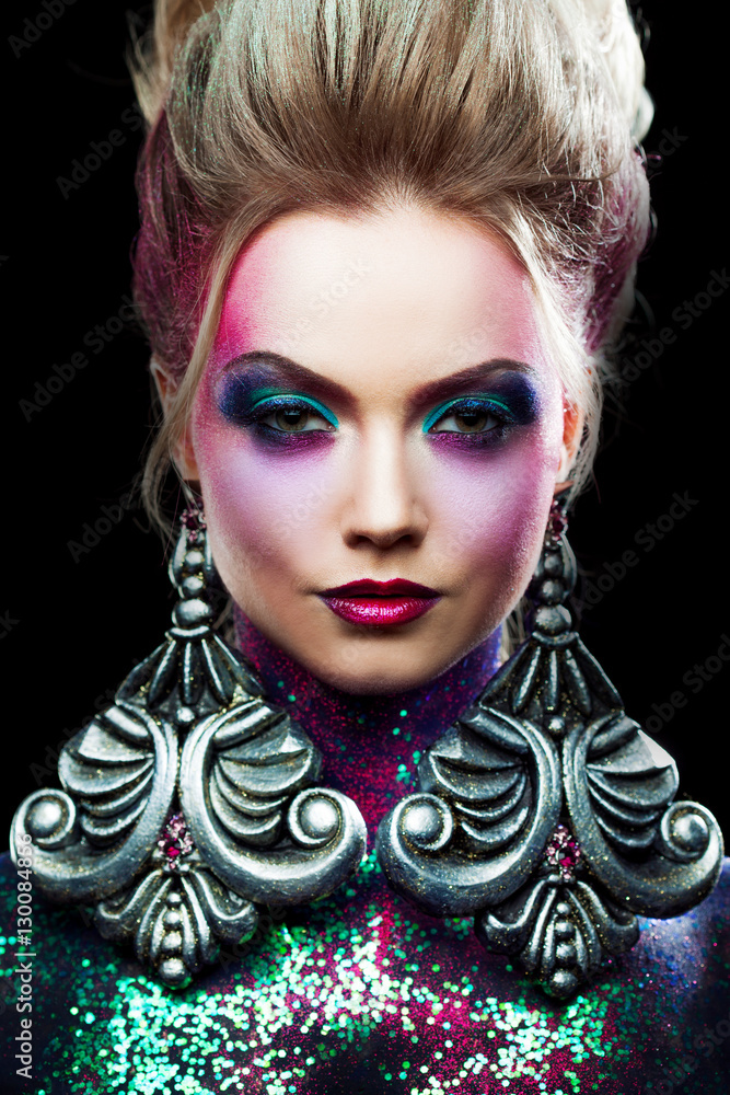 Young attractive blonde girl in bright art-makeup, high hair, body painting. Rhinestones and glitter Young attractive blonde girl in bright art-makeup, high hair, body painting. Rhinestones and glitter