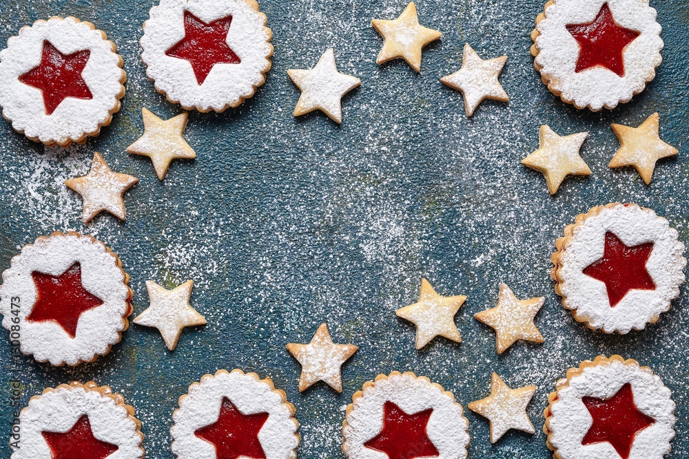 Assorted cookies. Cookie stars. Christmas festive homemade ginger cookies with strawberry jam. Copy space. Flat lay. Traditional Austrian Linzer cookie on green background. Top view.