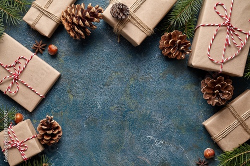 New Year or Christmas presents flat lay background design decor template wrapped with ribbon Xmas holiday season celebration handmade gift box and fir tree cones on vintage wooden table background.