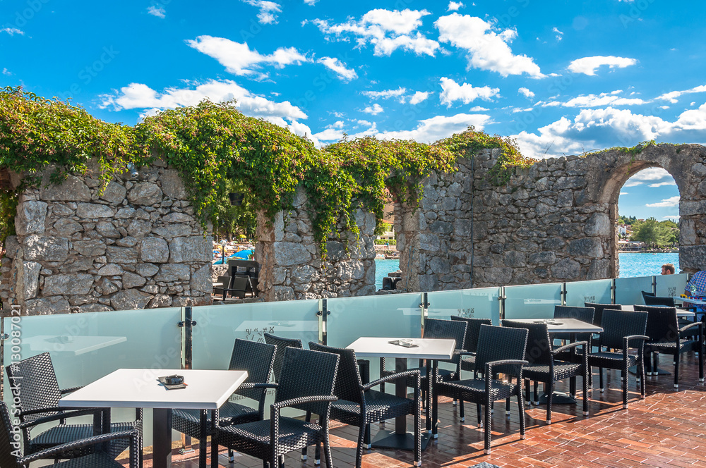 Fototapeta premium luxury lounge bar with picturesque ruins near the sea , Njivice, Krk Island, Croatia 