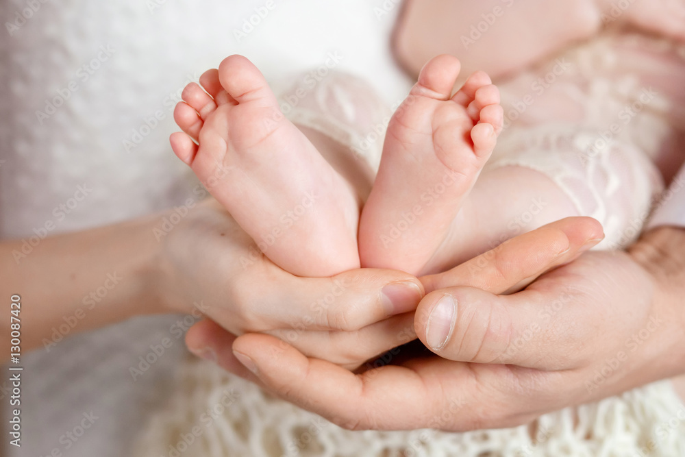 Baby feet in parents hands. Tiny Newborn Baby's feet on parents - obrazy, fototapety, plakaty 