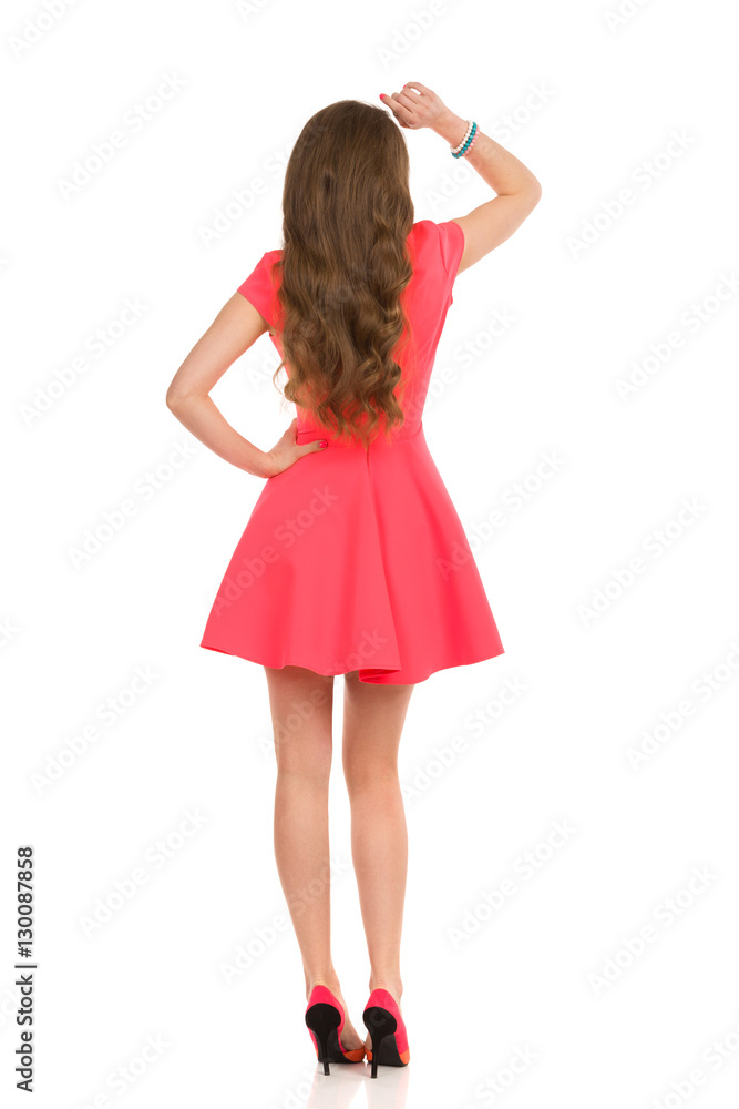 Woman In Pink Mini Dress And High Heels. Rear View.