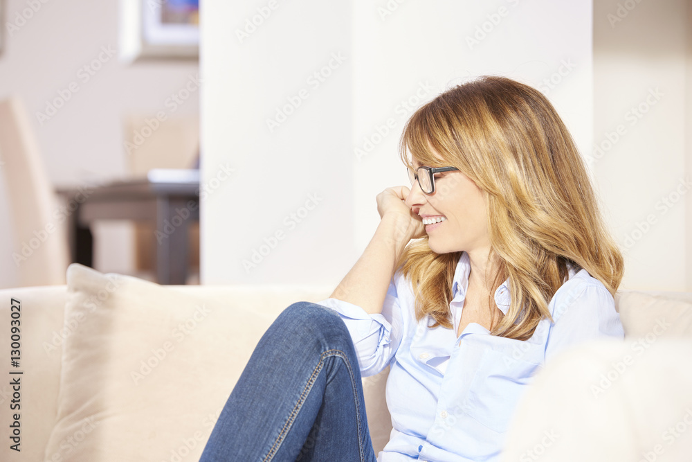 Chilling at home. Close-up shot of a smiling happy woman at home while relaxing on the sofa. Chilling at home. Close-up shot of a smiling happy woman at home while relaxing on the sofa.