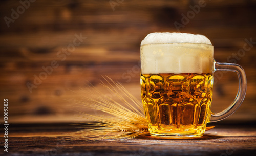 Glass of lager served on old wooden planks,