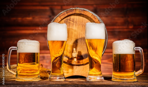 Glasses of lager with old wooden keg