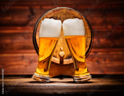 Obraz na plátne Glasses of lager with old wooden keg