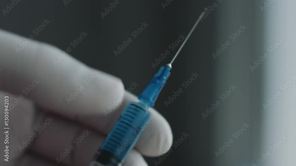 Doctor preparing a syringe for injection. Close-up shot Doctor preparing a syringe for injection. Close-up shot