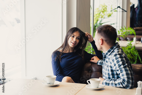 Happy couple talking at cafe, drinking tea