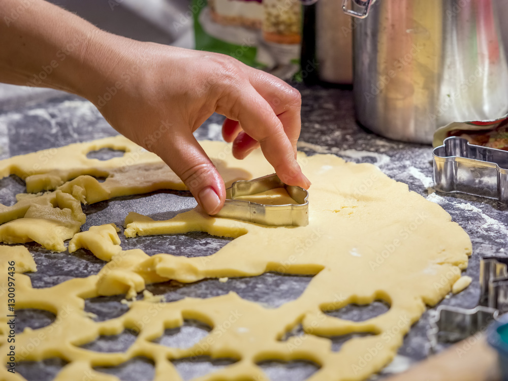 Baking cookies for Christmas. Young woman making shaped cookies.