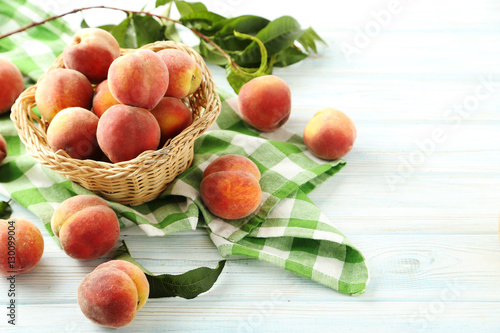 Fototapeta Naklejka Na Ścianę i Meble -  Sweet peach fruit in basket on white wooden table