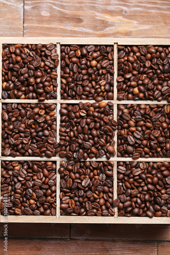 Roasted coffee beans in wooden basket on brown table Roasted coffee beans in wooden basket on brown table