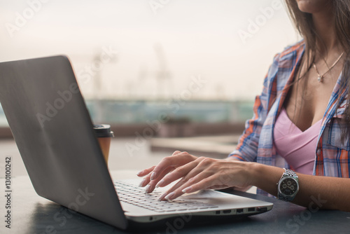 Close up shot of female hands typing on a laptop keyboard.