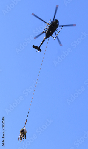 A helicopter carries workmen from one high voltage tower to the next as they install power cables