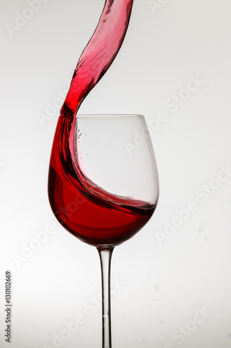 Rotweinglas schwappt über photo