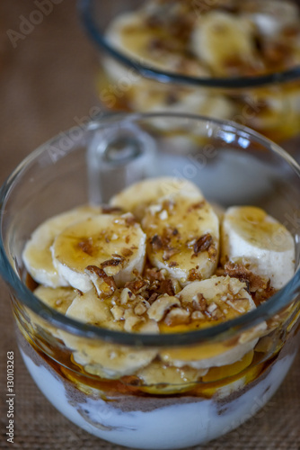 Granola with yogurt, bananas and whole walnuts, maple syrup clea