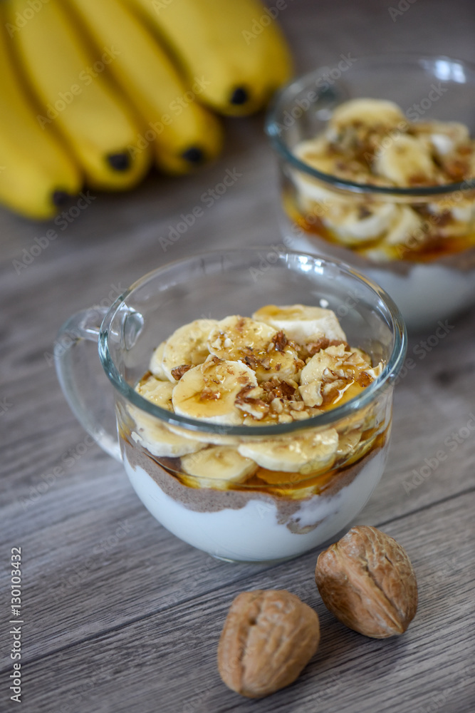 Granola with yogurt, bananas and whole walnuts, maple syrup clea Granola with yogurt, bananas and whole walnuts, maple syrup clea