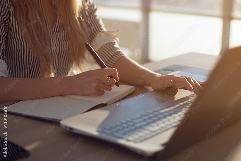 Woman freelancer female hands with pen writing on notebook at home or office - obrazy, fototapety, plakaty 