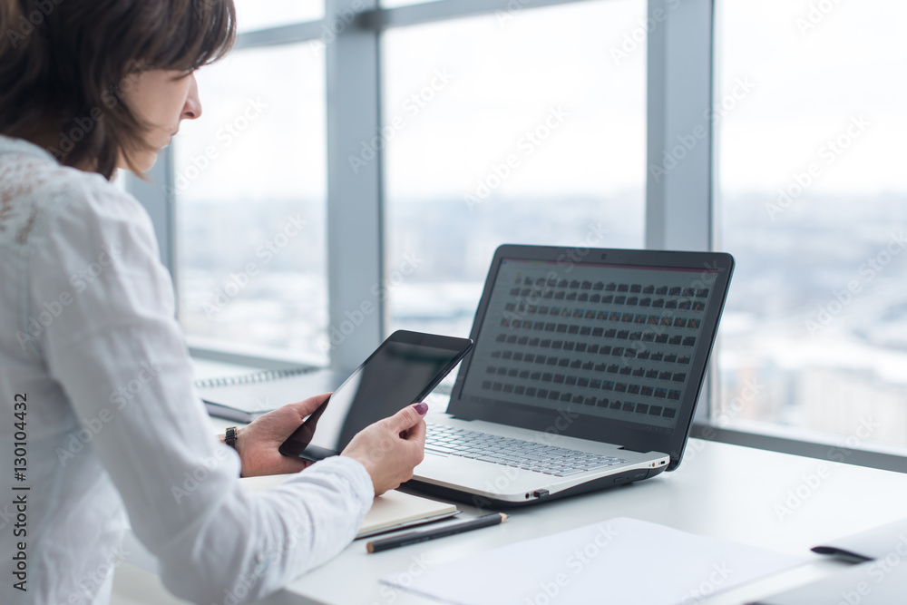 Woman working with tablet pc and laptop computer on table