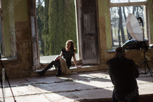 Photographer in motion, doing a photo shoot. Focus on model