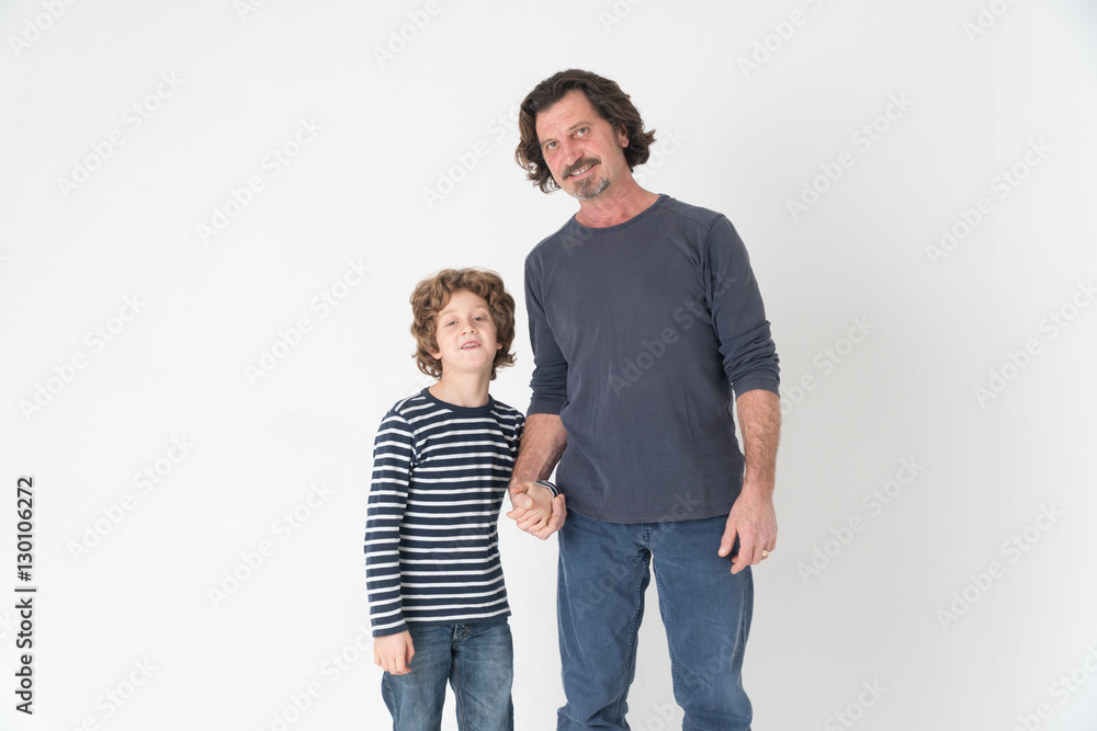 Father posing hand in hand with his son on white background