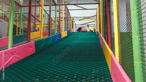 the little girl on the tubing rolls with slides in the play area