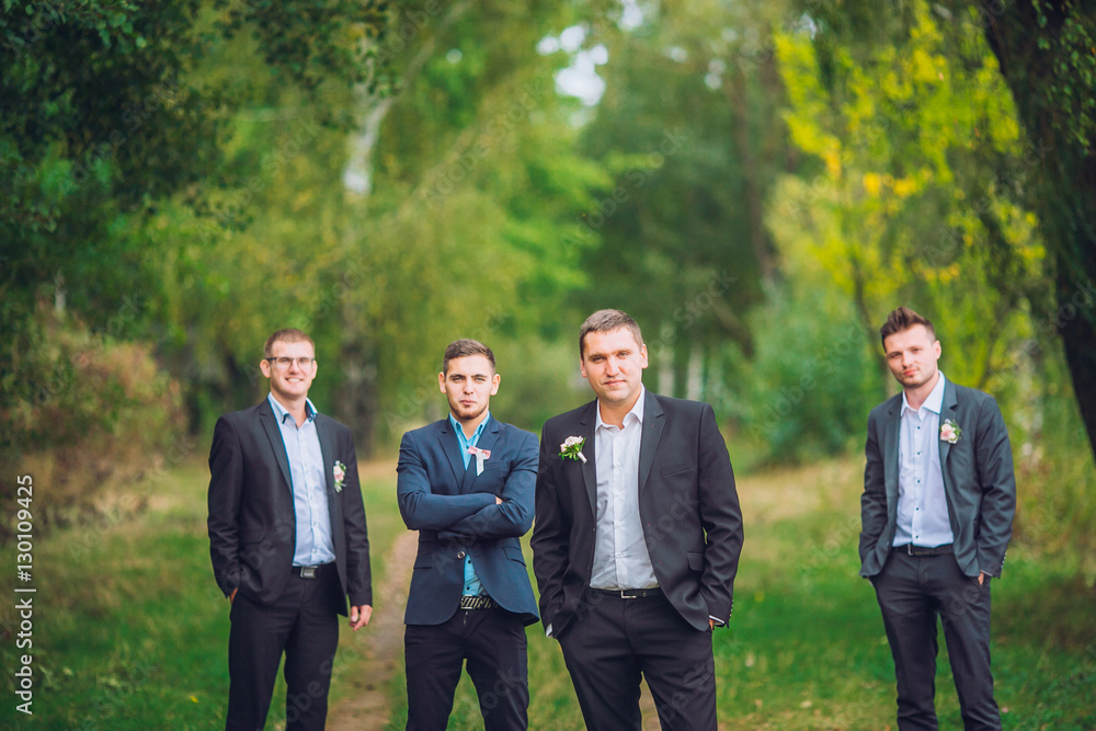 Personable groom with best mans or groomsman posed on park at wedding day. Personable groom with best mans or groomsman posed on park at wedding day.