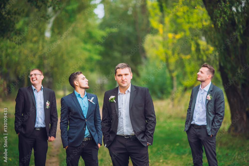 Personable groom with best mans or groomsman posed on park at wedding day. Personable groom with best mans or groomsman posed on park at wedding day.