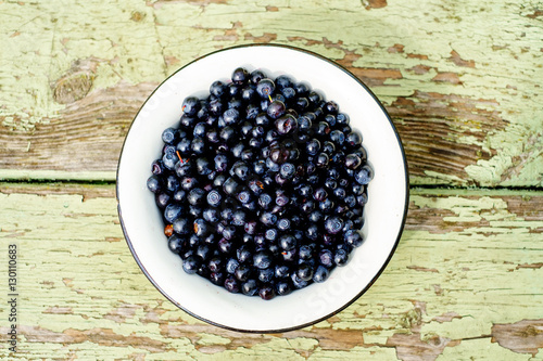 Dish of ripe blueberries on old wooden table