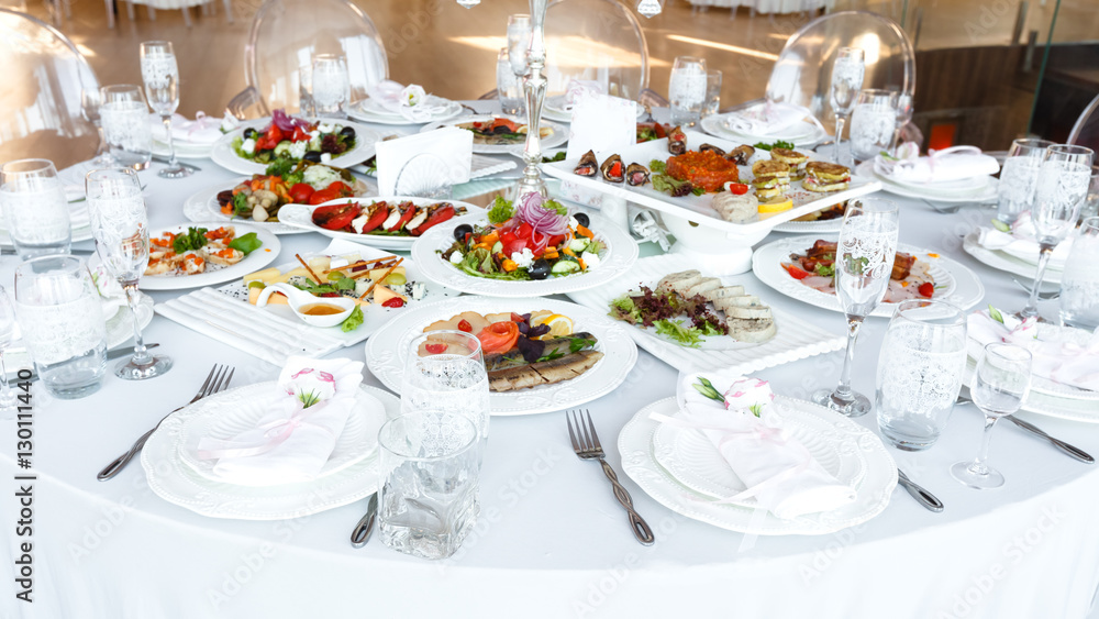 decorated table with meal and tableware at wedding reception