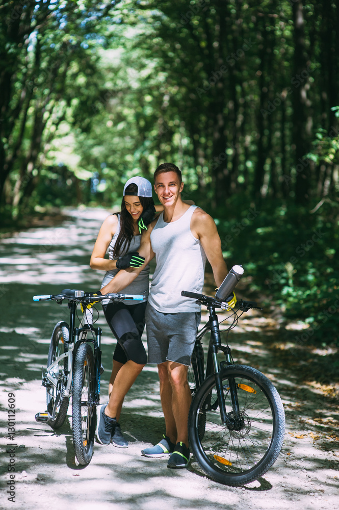 Young Couple Riding Bike In Park